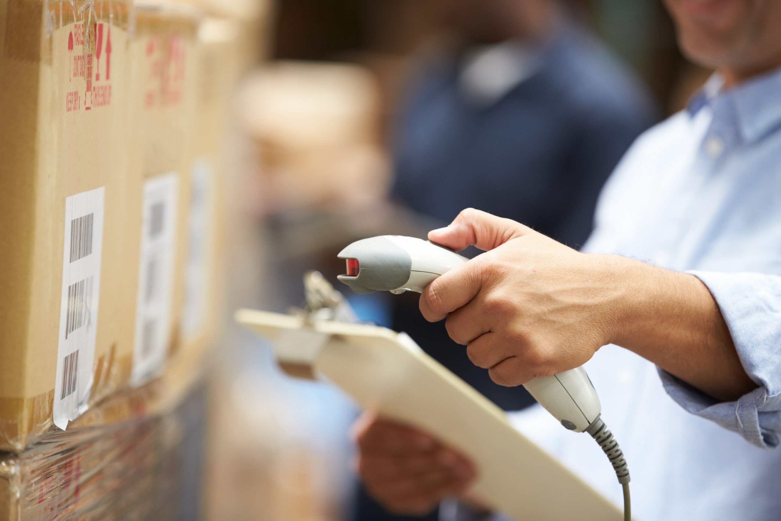 A worker scanning a package In a warehouse.